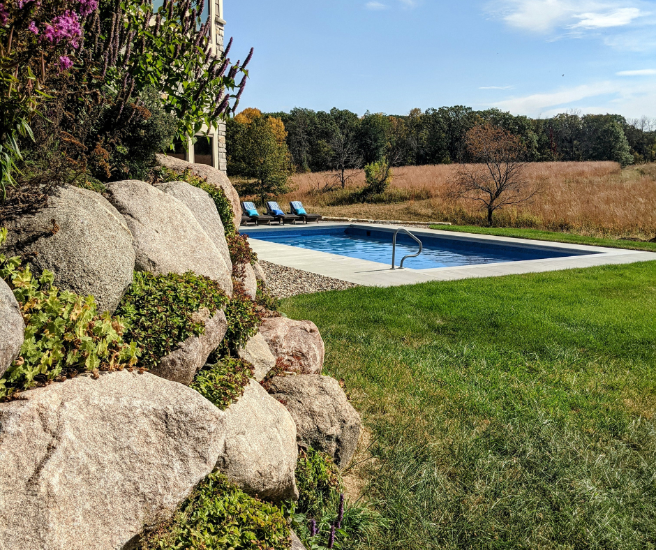 backyard pool in rural area with green grass