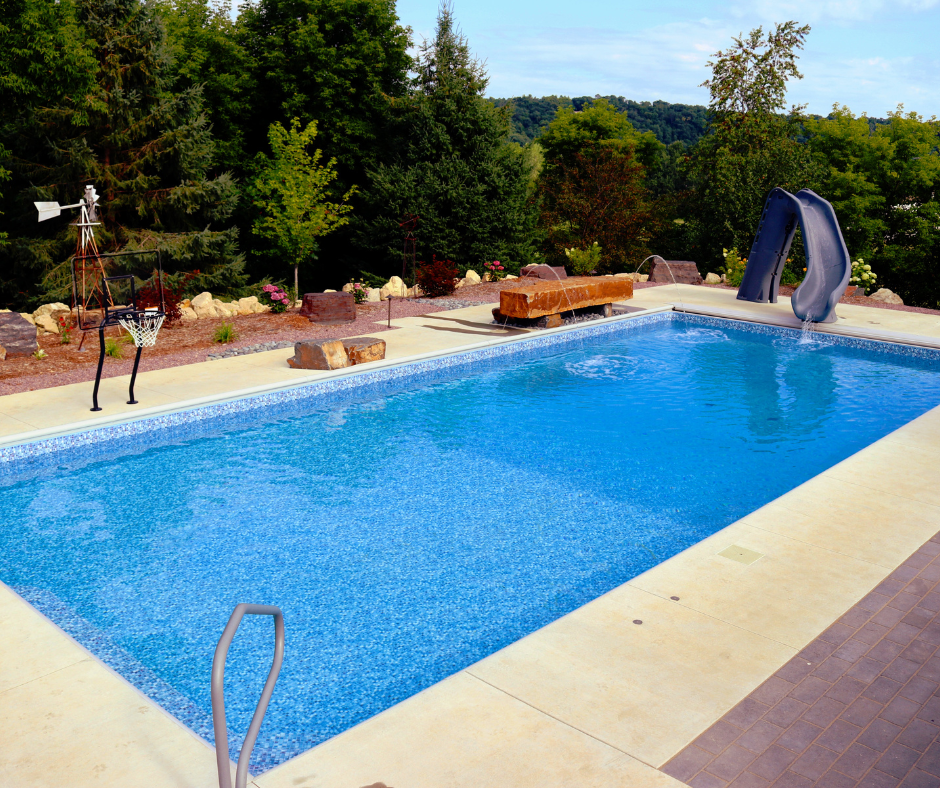 rectangular pool with slide and hills in background