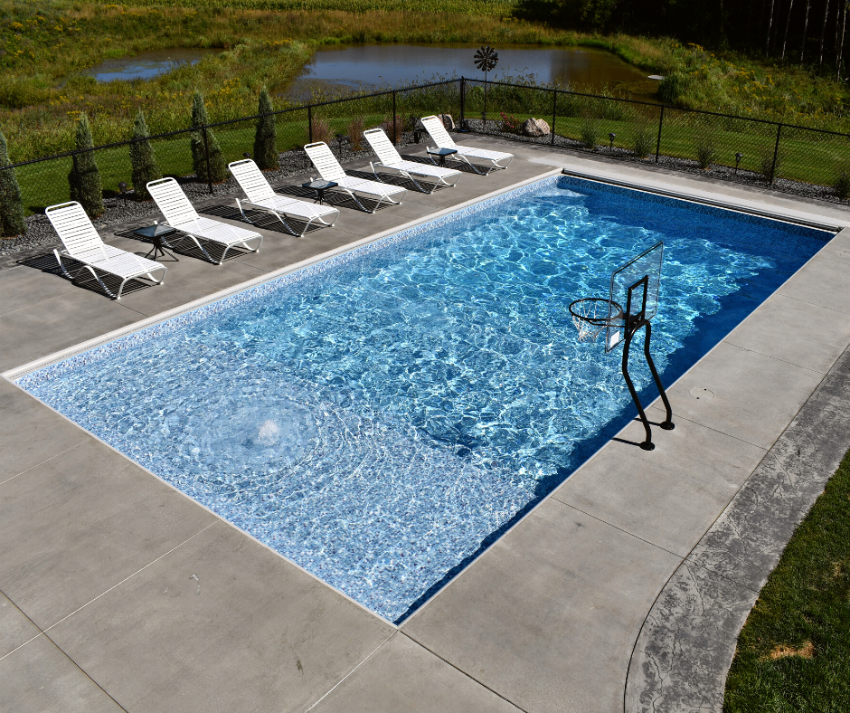 rectangular pool with loungers and basketball hoop